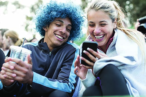 A young couple looking at a mobile phone to explore a Blue Access for Members account.